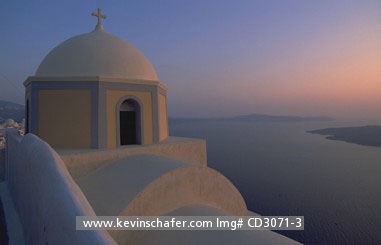 GREECE, SANTORINI: Cyclades Islands, Church on crater rim at dusk looking out at ocean.