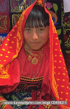 PANAMA, PEOPLE: Young Kuna (Cuna) woman wearing, sewing and selling molas in San Blas Islands, Panama.