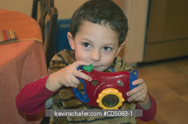 BOY: Three year old boy, playing with toy camera gift, Christmas Day, Portland, Oregon. MODEL RELEASED