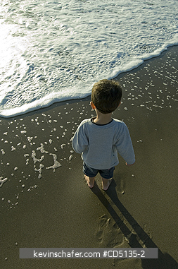 PEOPLE, CHILDREN: Young boy playing in surf on beach, 4 years old, Oregon coast, model released.