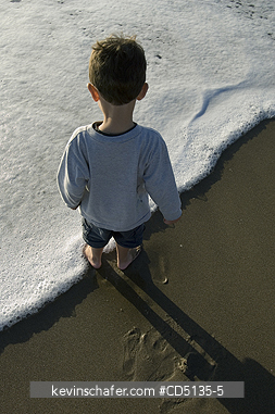 PEOPLE, CHILDREN: Young boy playing in surf on beach, 4 years old, Oregon coast, model released.