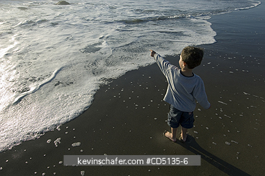 PEOPLE, CHILDREN: Young boy playing in surf on beach, 4 years old, Oregon coast, model released.