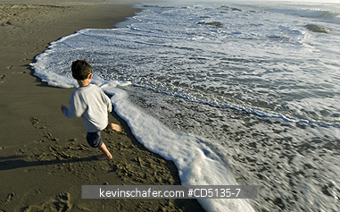 PEOPLE, CHILDREN: Young boy playing in surf on beach, 4 years old, Oregon coast, model released.
