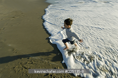 PEOPLE, CHILDREN: Young boy playing in surf on beach, 4 years old, Oregon coast, model released.