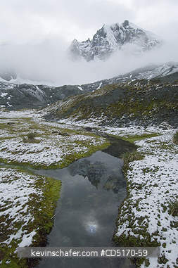 SOUTH GEORGIA ISLAND: Sun and mountains reflected in meltwater stream after summer snowfall, Diaz Cove area, Southwest coast of South Georgia island, sub-Antarctic December 2005