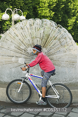 NORWAY, PEOPLE: Boy on bicycle, National Theatre fountain, Oslo, Norway