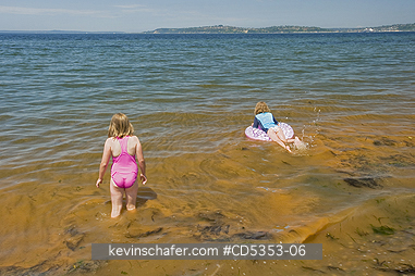 TIDES, RED: Girls play in Red Tide, Alki Beach,  Seattle, Puget Sound, Washington