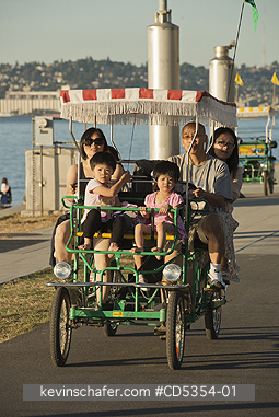 SEATTLE: Family rides pedal surrey, Alki Beach, Puget Sound, Seattle, Washington SUMMER