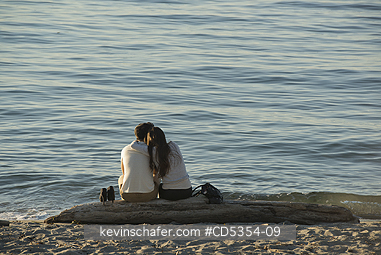 SEATTLE: Couple on beach log, Alki Beach, Seattle, Washington SUMMER