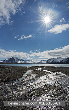NORWAY, SVALBARD: Sun over meltstream, Engelsbukta, Svalbard, arctic Norway