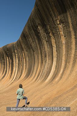 AUSTRALIA, PEOPLE: Woman and Wave Rock, striking granite formation, Western Australia
