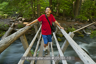 OREGON, PEOPLE: Theo Braibish, aged 12, crossing river bridge, Mt. Hood National Forest, Oregon