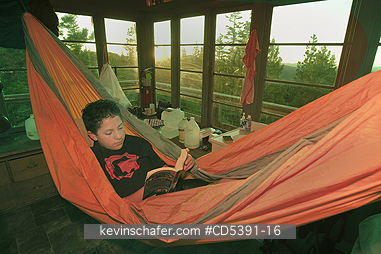 OREGON, PEOPLE: Theo Braibish, aged 12, reading in hammock, Five Mile Butte lookout tower, Mt. Hood National Forest, Oregon