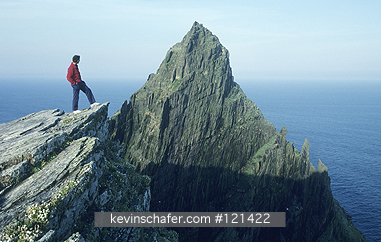 IRELAND: Ireland, County Kerry, Skellig Island, Hiker standing atop Skellig Michael in June.