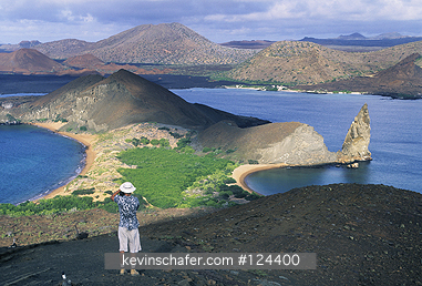 ECUADOR, GALAPAGOS ISLANDS: Ecuador, Galapagos Island, Bartolome Island, tourist at sunrise, James Island in distance.