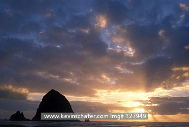 OREGON: USA, Oregon, Cannon Beach, Sunset over Haystack Rock.