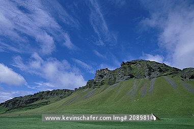 ICELAND: Iceland, South coast near Vik, Green hills and turf-roof cottage.