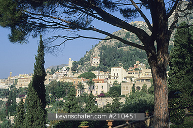 ITALY: Italy, Siciliy, Taormina, Trees frame view of old town.