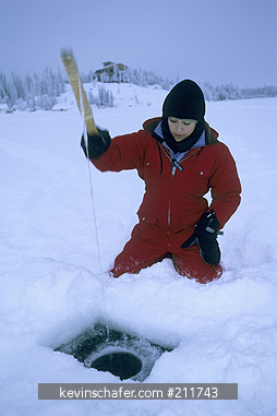 CANADA, ARCTIC: Blachford Lake, Great Slave Lake area, Kristine Jaramillo ice-fishing, Northwest Territories, January.