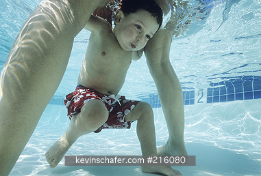 CHILD: Boy, aged 2, swimming between mom\'s legs, Hawaii