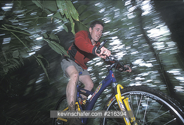 COSTA RICA, PEOPLE: Arenal Volcano area, Fortuna, man bicycling in the rainforest. MR
