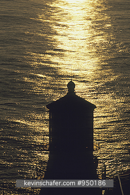 USA, CALIFORNIA: Lighthouse at sunset, silhouetted against the sea, Point Reyes National Seashore.