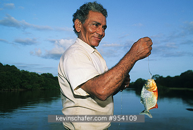VENEZUELA, PEOPLE: Llanos, Hato Cedral, man fishing for piranha.