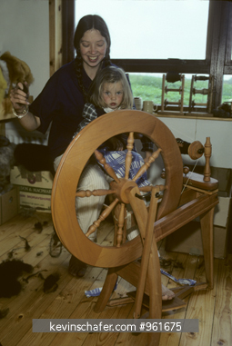 SCOTLAND, PEOPLE: Penny Millsopp with daughter at spinning wheel, Isle of Foula, Shetland Islands.